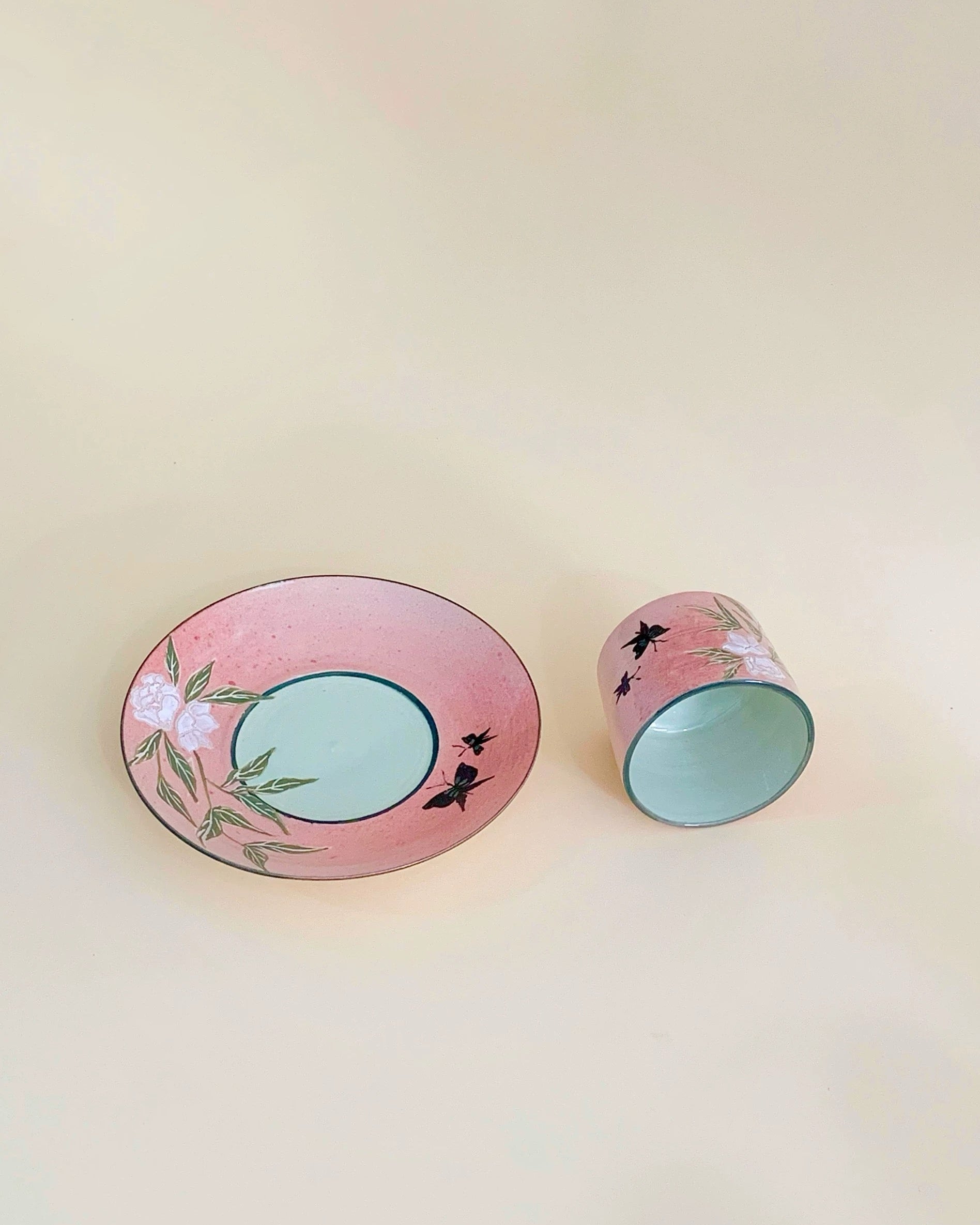 Two ceramic items with floral and butterfly designs on a light pink background from Untable