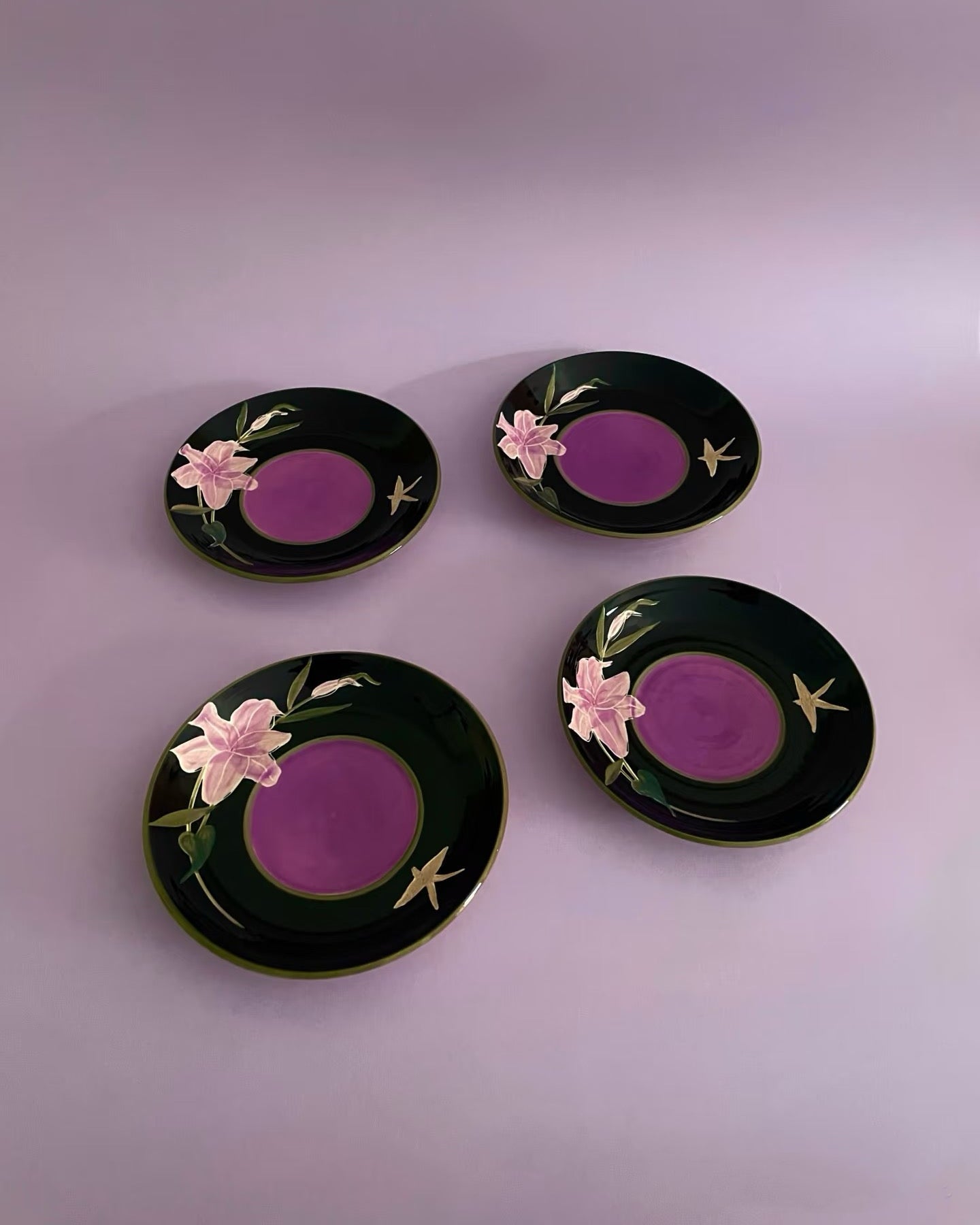Four decorative plates with floral designs on a purple background frm Untable