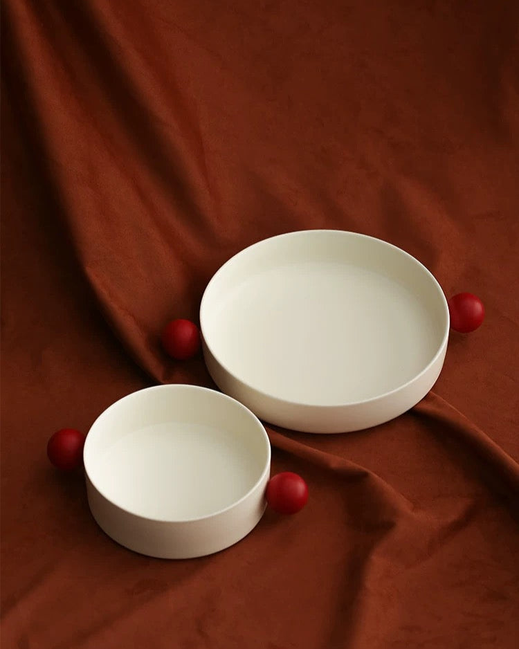 A white ceramic decorative bowl with red accents designed for serving snacks or as a decorative piece from Untable
