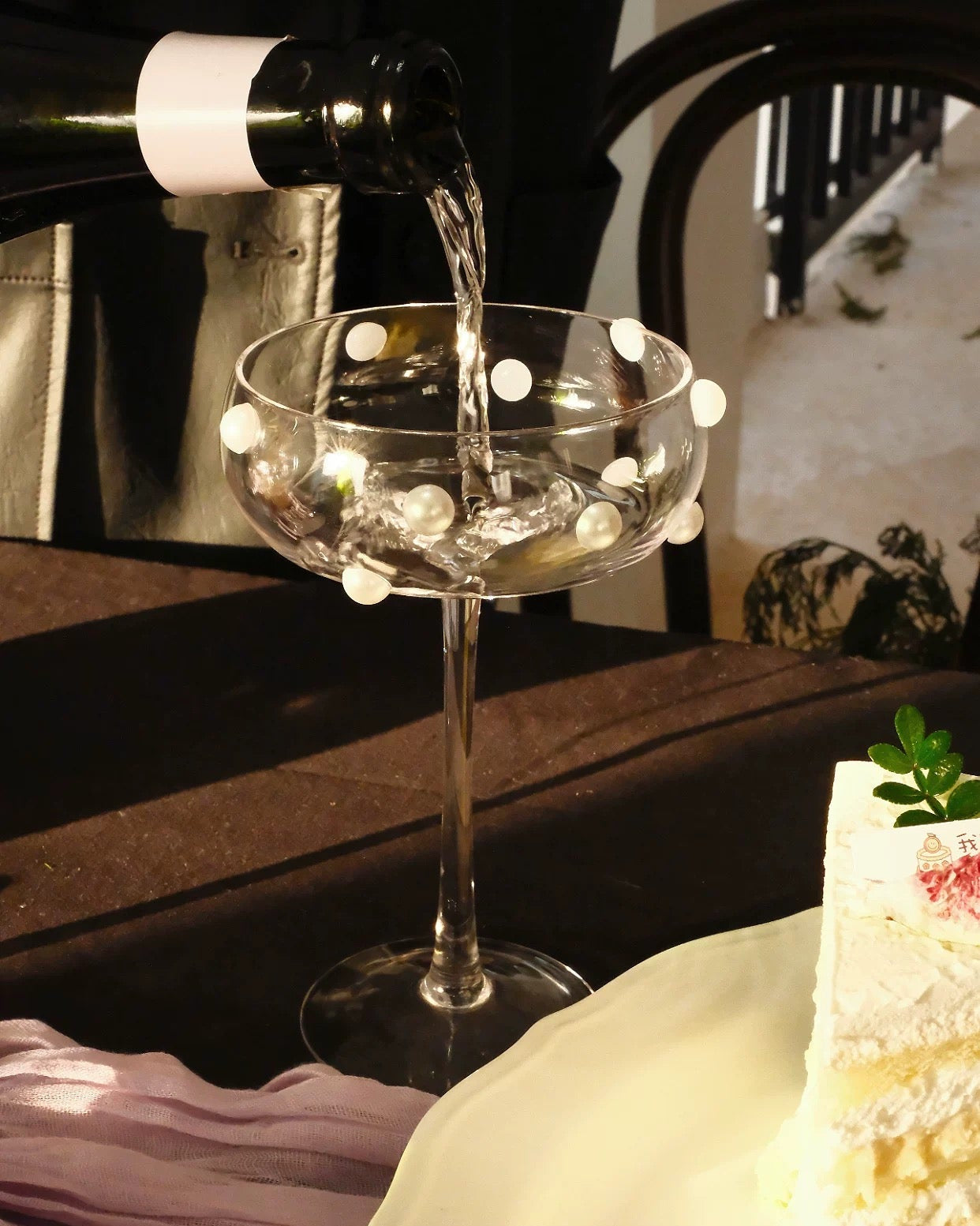 Wine being poured into a glass with a cake in the foreground from Untable